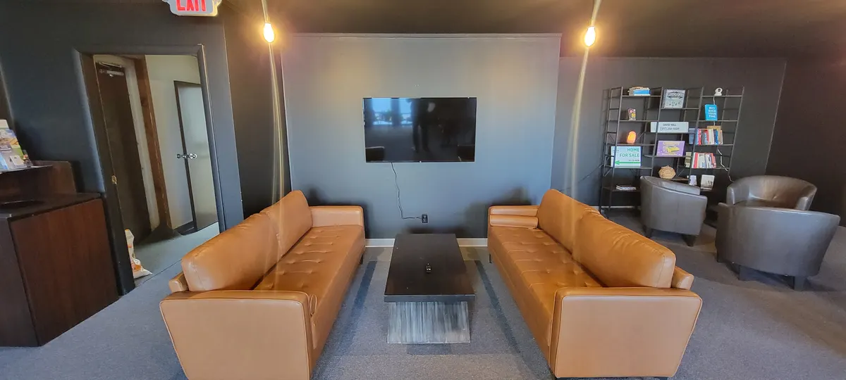 Cafe Room lounge area with two leather sofas facing a wall-mounted TV
