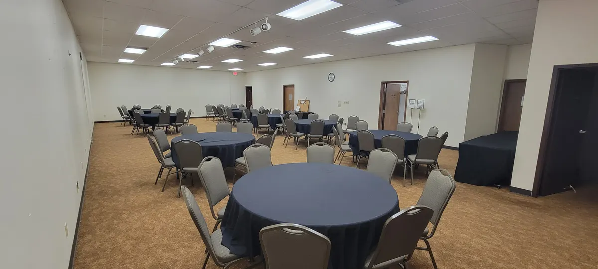 The Grand Room set with round tables in navy linens and cushioned banquet chairs