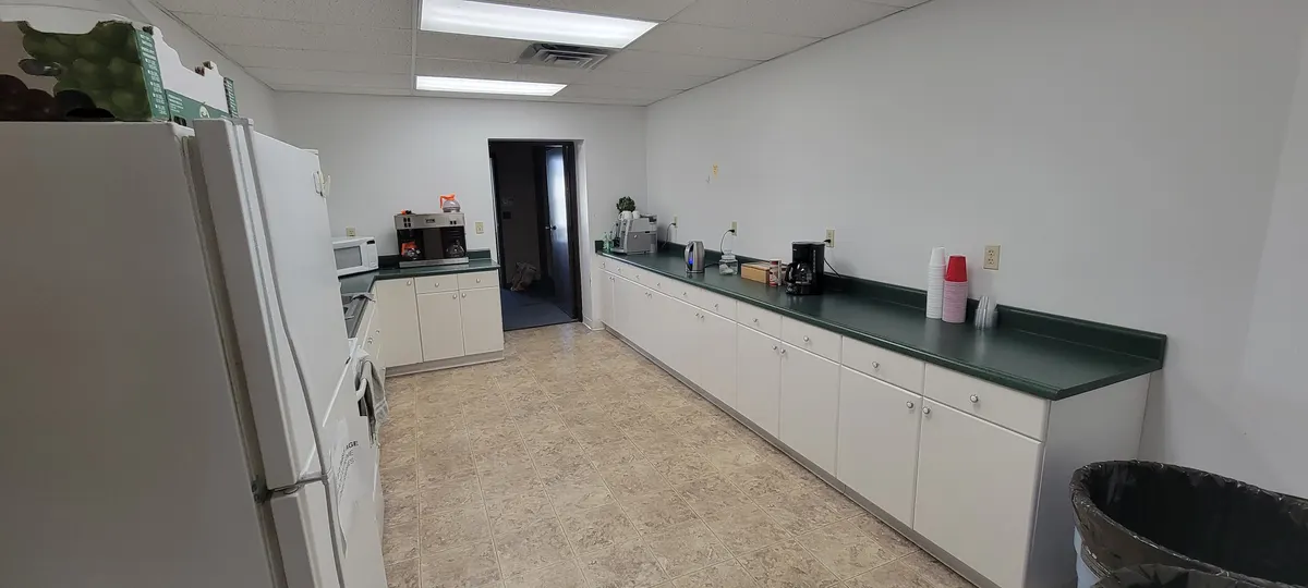 Kitchen counter run with coffee makers, cups and cabinet storage