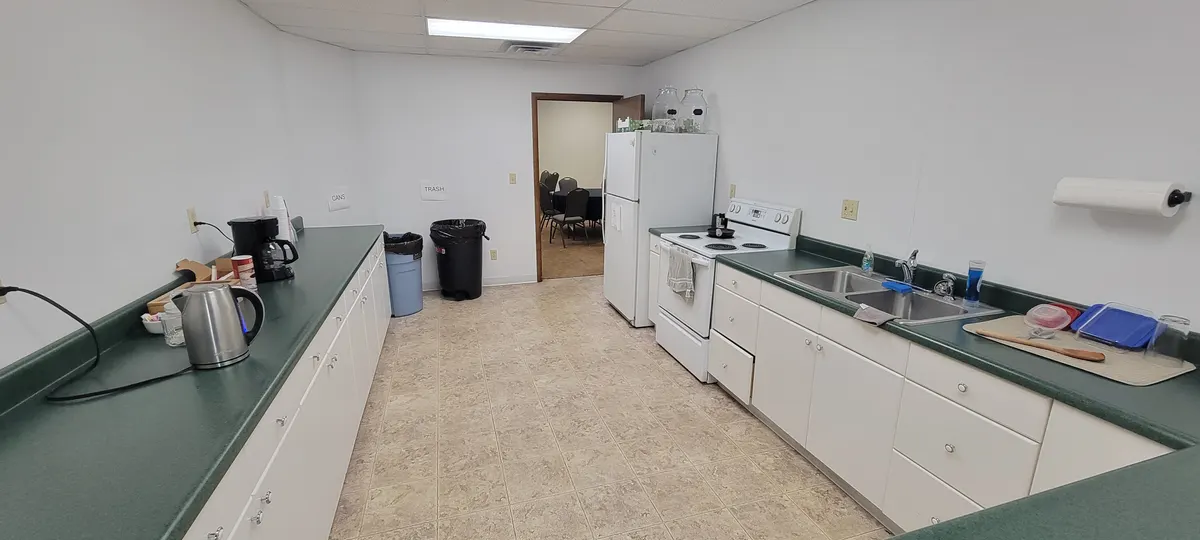 Kitchen with a full-size refrigerator, electric range and oven, double sink and long counters