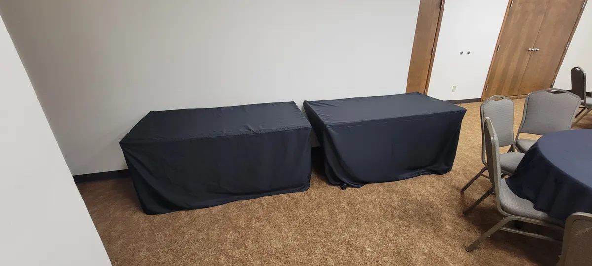 Two five-foot serving tables draped in navy linens